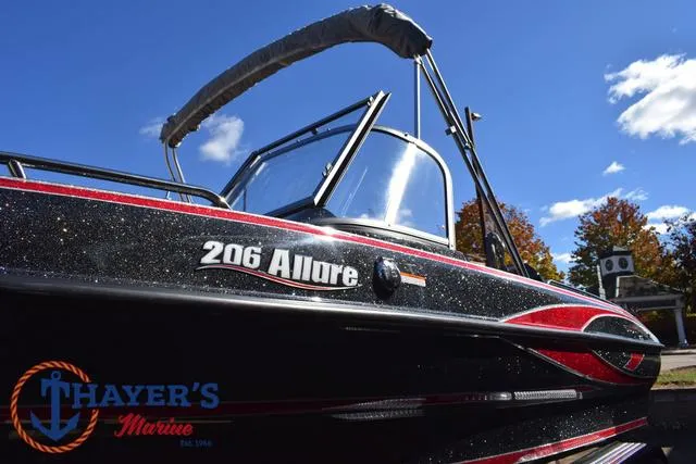 Slide: The Image of 2024 Triton 206 Allure boat with canopy under blue sky. - 45