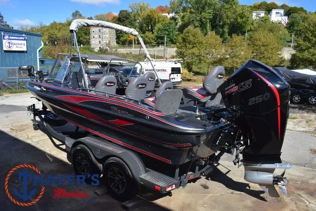 Slide: The Image of 2024 Triton 206 Allure boat with Mercury 250 engine, parked outdoors. - 9