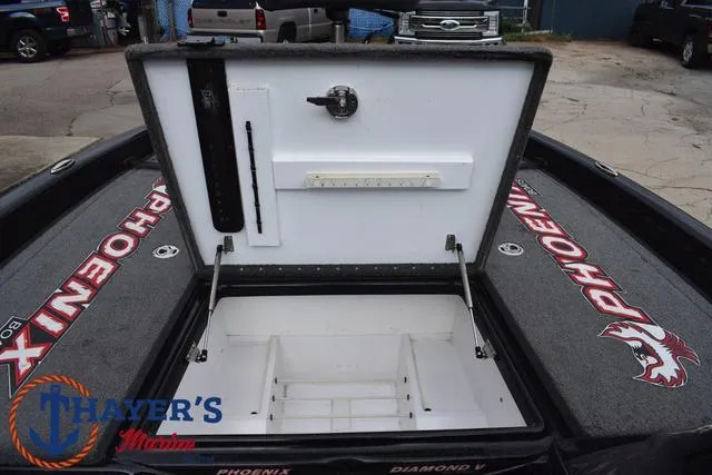 Slide: The Image of 2017 Phoenix Bass Boats 920 ProXP open storage compartment with branded carpet and Thayer's Marine logo. - 18