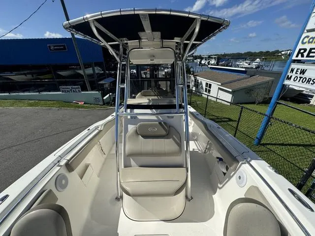 Slide: The Image of 2022 Key West 239FS boat with T-top, docked at marina under clear sky. - 7