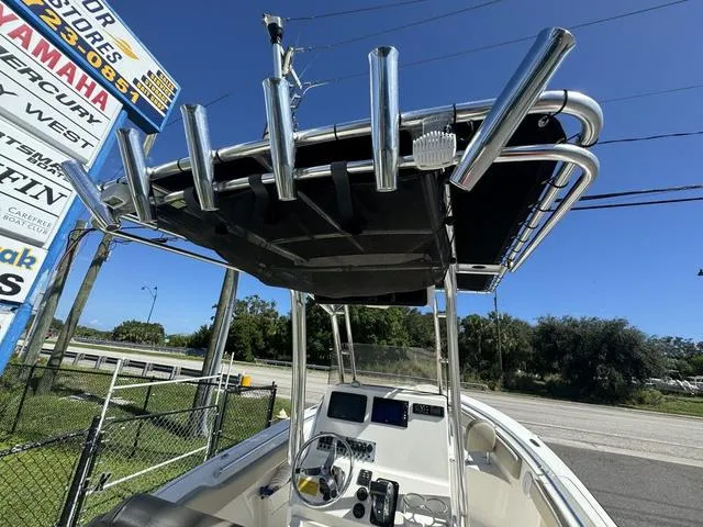 Slide: The Image of 2022 Key West 239FS boat with T-top and console, parked near dealership signs. - 9