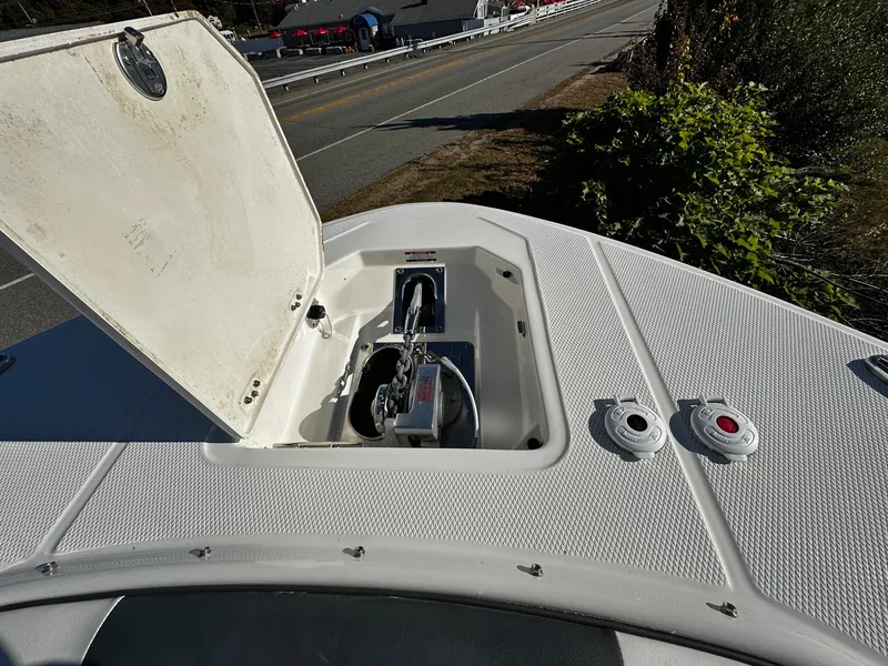 Slide: The Image of 2022 Robalo R317 Dual Console boat anchor compartment open on deck. - 11