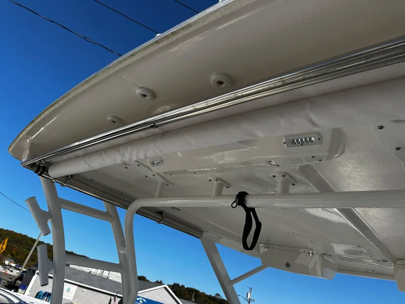 Slide: The Image of 2022 Robalo R317 Dual Console boat canopy and structure under clear blue sky. - 12