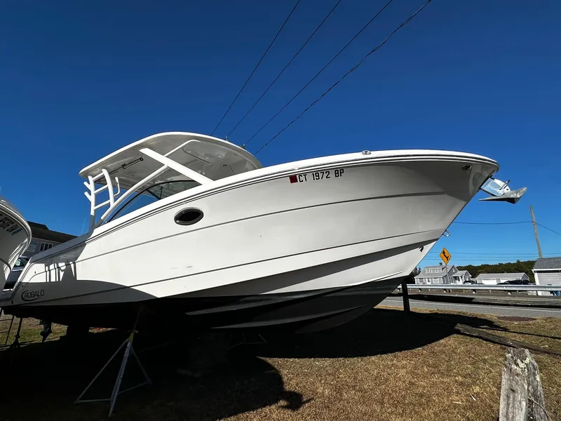 Slide: The Image of 2022 Robalo R317 Dual Console boat displayed outdoors under clear blue sky. - 3