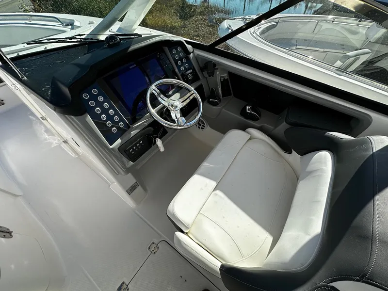 Slide: The Image of 2022 Robalo R317 Dual Console boat cockpit with steering wheel and control panel. - 8
