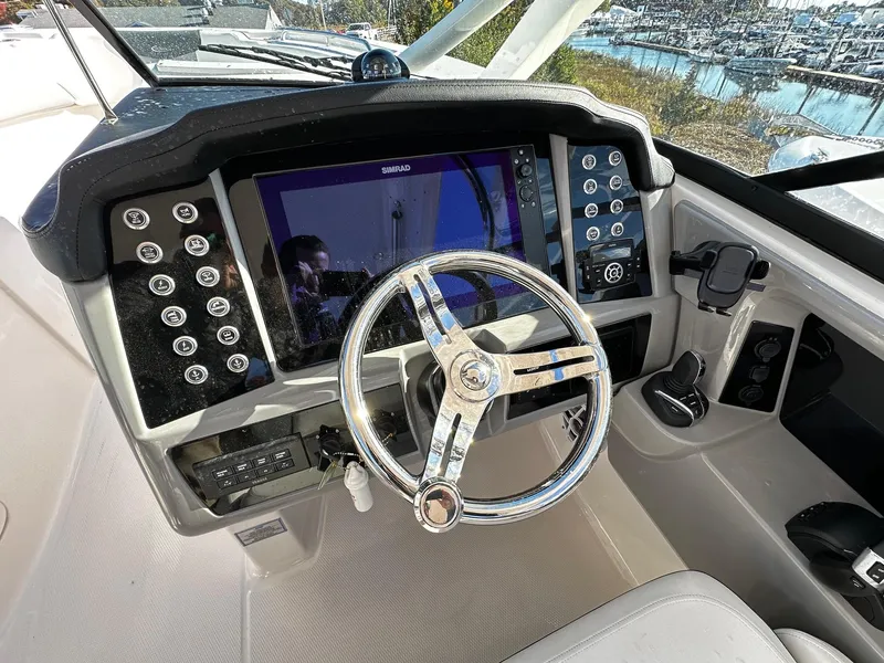 Slide: The Image of 2022 Robalo R317 Dual Console boat dashboard with steering wheel and control panel. - 9