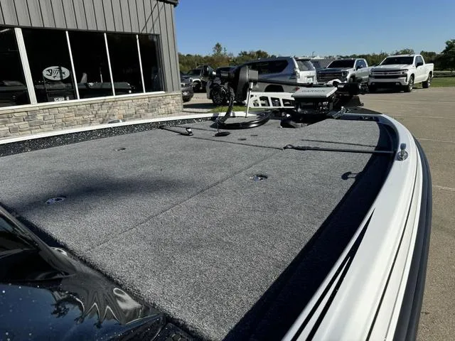 Slide: The Image of 2025 Phoenix 721 ZXL boat deck with fishing equipment, parked outside dealership. - 5