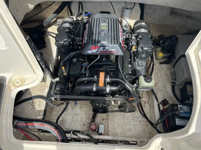 Slide: The Image of Engine compartment of a 2001 Rinker 243 Siesta DB boat, featuring a 5.7L MerCruiser engine. - 10