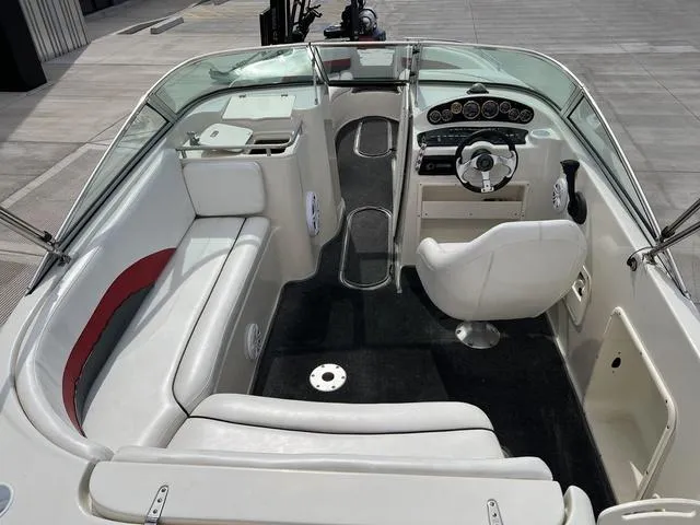 Slide: The Image of Interior of a 2001 Rinker 243 Siesta DB boat with white seating and dashboard. - 11