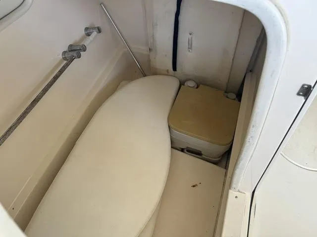 Slide: The Image of 2001 Rinker 243 Siesta DB boat interior with storage and portable toilet. - 12