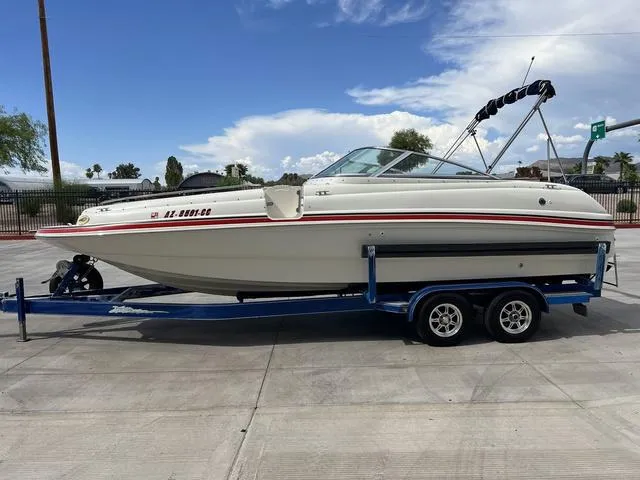 Slide: The Image of 2001 Rinker 243 Siesta DB boat on trailer, parked outdoors. - 3