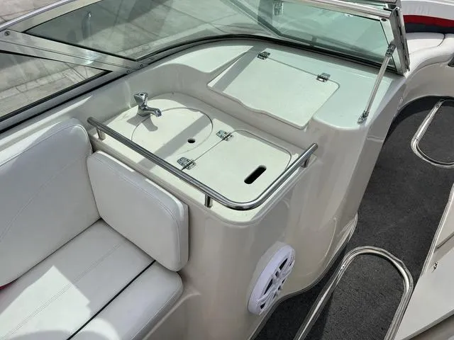 Slide: The Image of 2001 Rinker 243 Siesta DB boat interior with white seating and storage area. - 9