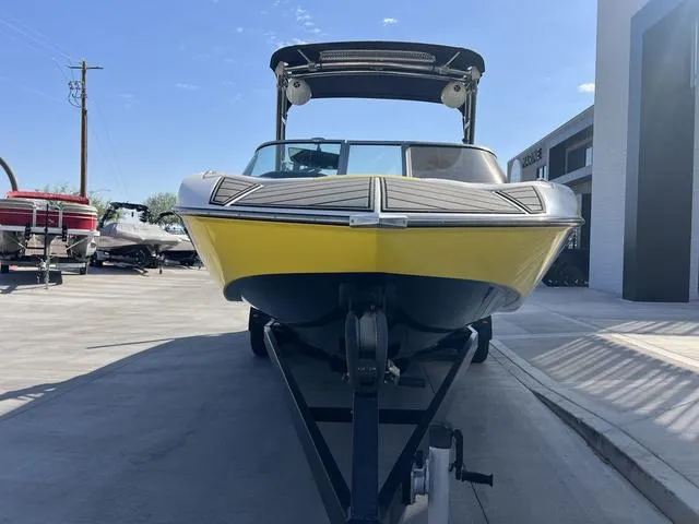 Slide: The Image of 2015 MB SPORTS B52 23 boat with yellow hull on trailer in sunny marina. - 3