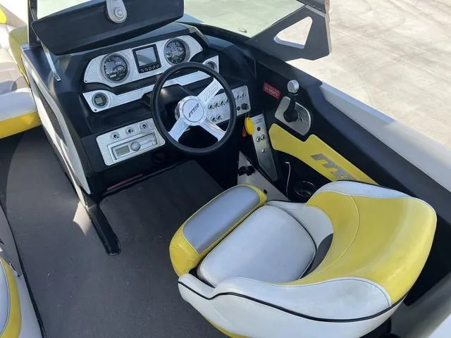 Slide: The Image of 2015 MB SPORTS B52 23 boat interior with yellow and white captain's seat and dashboard controls. - 9