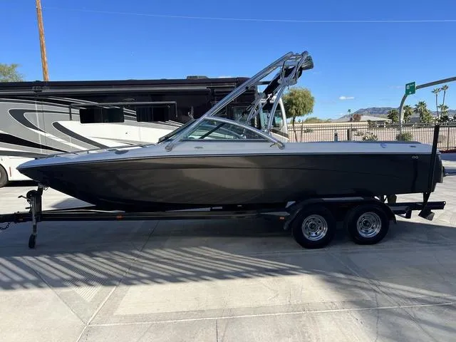 Slide: The Image of 2008 Supreme V232 boat on trailer, parked outdoors under clear blue sky. - 5