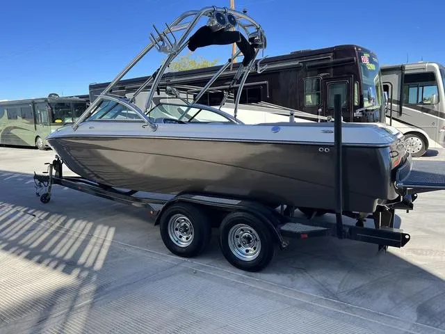 Slide: The Image of 2008 Supreme V232 boat on trailer, parked near RVs, under clear blue sky. - 6