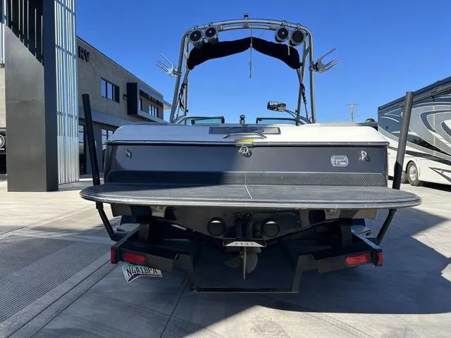 Slide: The Image of 2008 Supreme V232 boat rear view with wakeboard tower in a parking lot. - 7