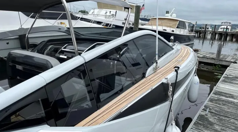 Slide: The Image of 2022 Fairline F//Line 33 yacht docked at marina, sleek design with wooden deck accents. - 23