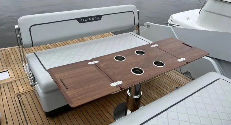 Slide: The Image of Fairline F//Line 33 yacht interior, 2022 model, featuring a wooden table and cushioned seating. - 26