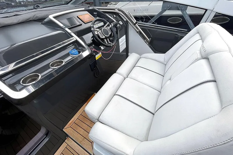 Slide: The Image of 2022 Fairline F//Line 33 yacht interior with sleek dashboard and plush seating. - 33