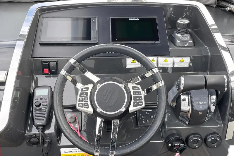 Slide: The Image of 2022 Fairline F//Line 33 helm with steering wheel, controls, and navigation screens. - 34