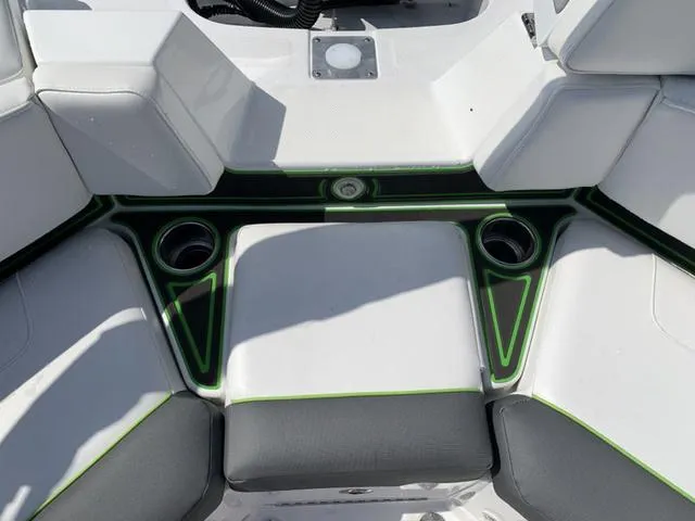 Slide: The Image of 2024 Tahoe 210 S boat interior with white and black seating, green accents, and cup holders. - 19
