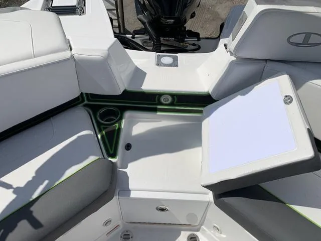 Slide: The Image of 2024 Tahoe 210 S boat interior with white and gray seating, cup holders, and storage compartments. - 20