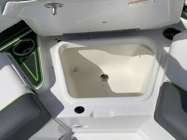 Slide: The Image of 2024 Tahoe 210 S boat interior storage compartment with cup holders and seating. - 21