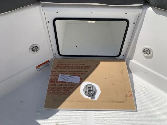 Slide: The Image of 2024 Tahoe 210 S boat storage compartment with protective cover and latch. - 26
