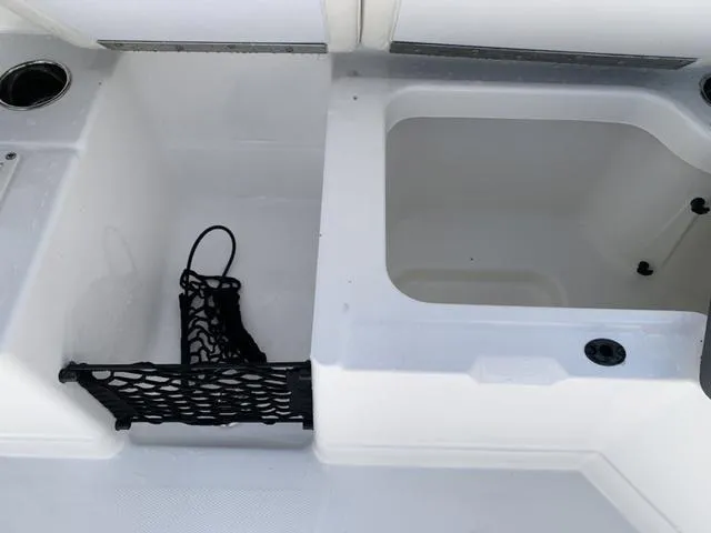 Slide: The Image of 2024 Tahoe 210 S boat storage compartments with netting and cup holder. - 28