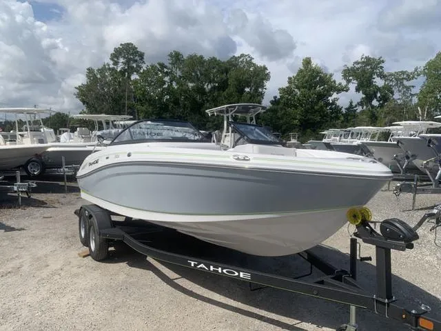 Slide: The Image of 2024 Tahoe 210 S boat on trailer, parked outdoors under cloudy sky. - 3