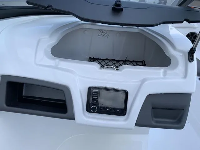 Slide: The Image of 2024 Tahoe 210 S boat dashboard with storage compartment and control panel. - 41