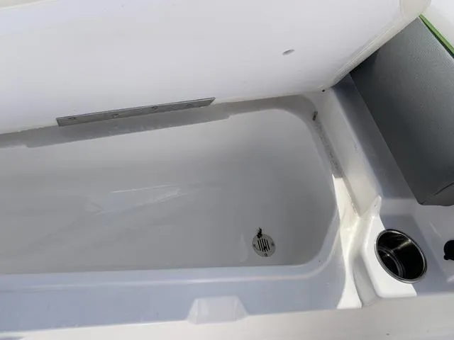 Slide: The Image of 2024 Tahoe 210 S boat storage compartment with drain and cup holder. - 44