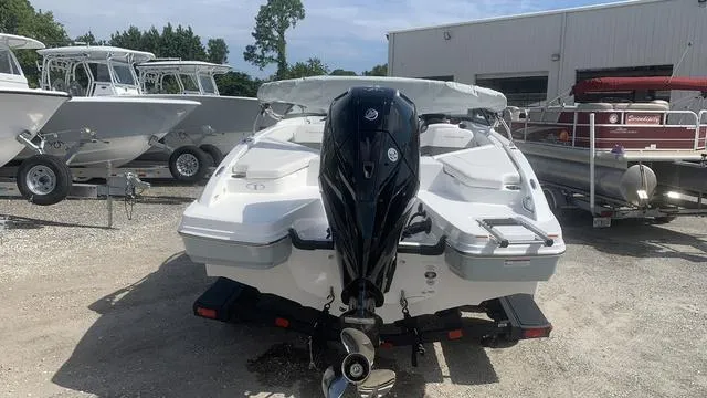 Slide: The Image of 2024 Tahoe 210 S boat with outboard motor in a marina setting. - 6