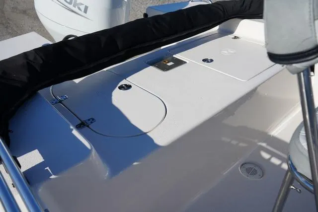 Slide: The Image of 2025 Carolina Skiff 178 JLS boat deck with storage compartments and Suzuki engine. - 12