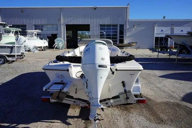 Slide: The Image of 2025 Carolina Skiff 178 JLS boat with Suzuki outboard motor, parked outside a marine facility. - 4