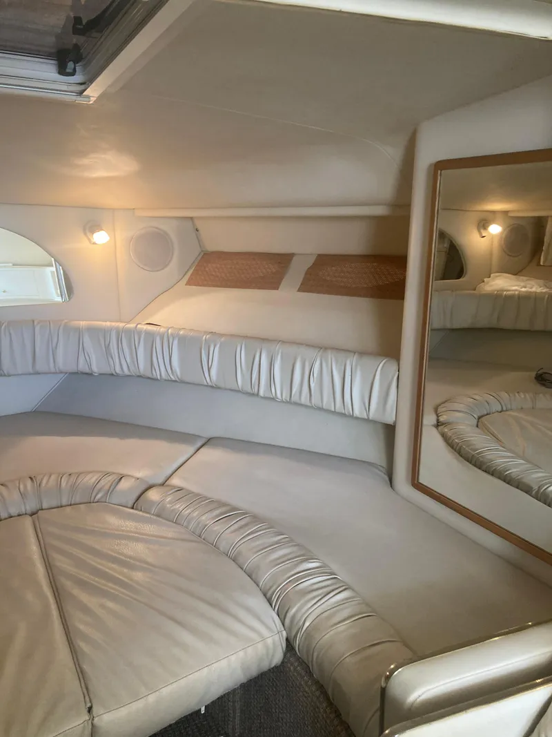 Slide: The Image of 1999 Sea Ray 330 Express Cruiser cabin interior with plush seating and mirror. - 10
