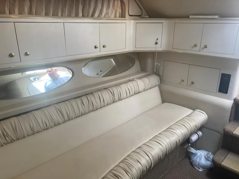 Slide: The Image of Interior of 1999 Sea Ray 330 Express Cruiser with beige seating and storage cabinets. - 15