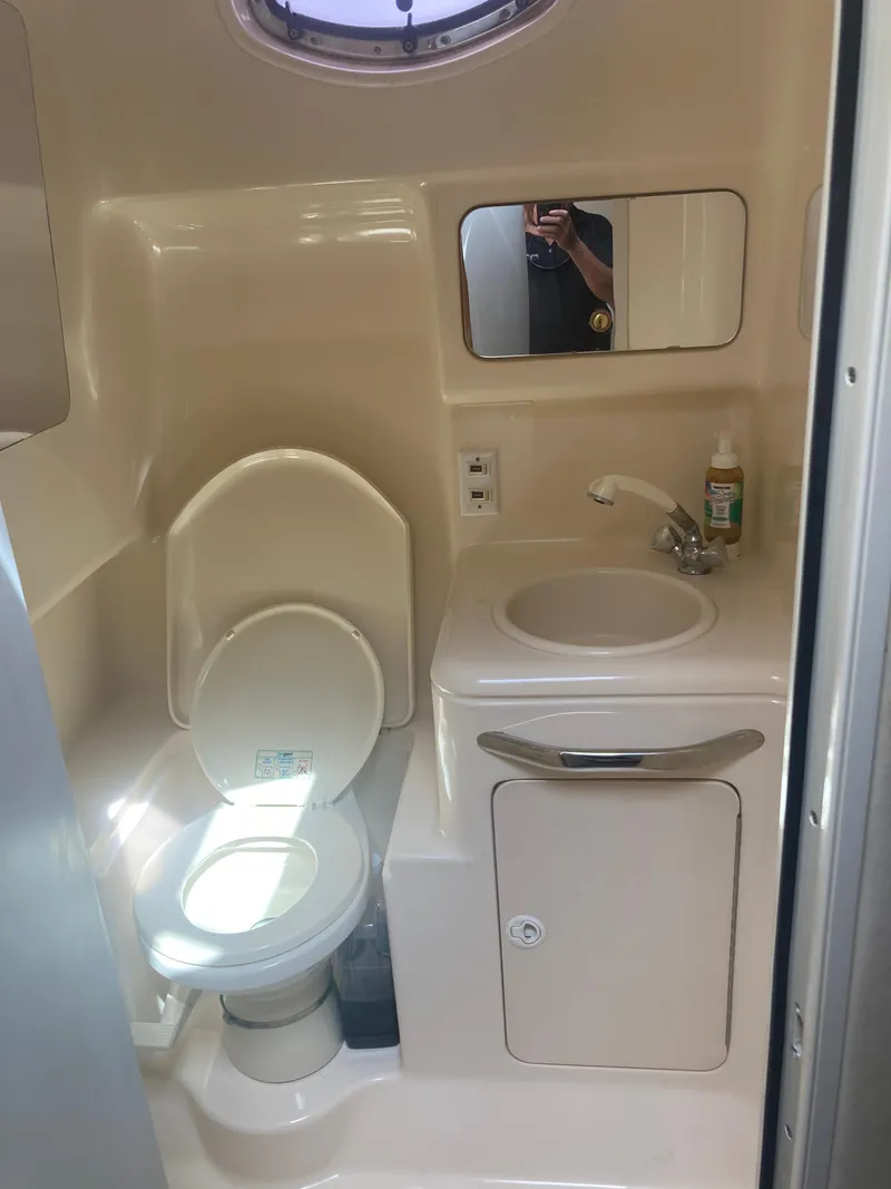 Slide: The Image of 1999 Sea Ray 330 Express Cruiser bathroom with toilet, sink, and mirror. - 21