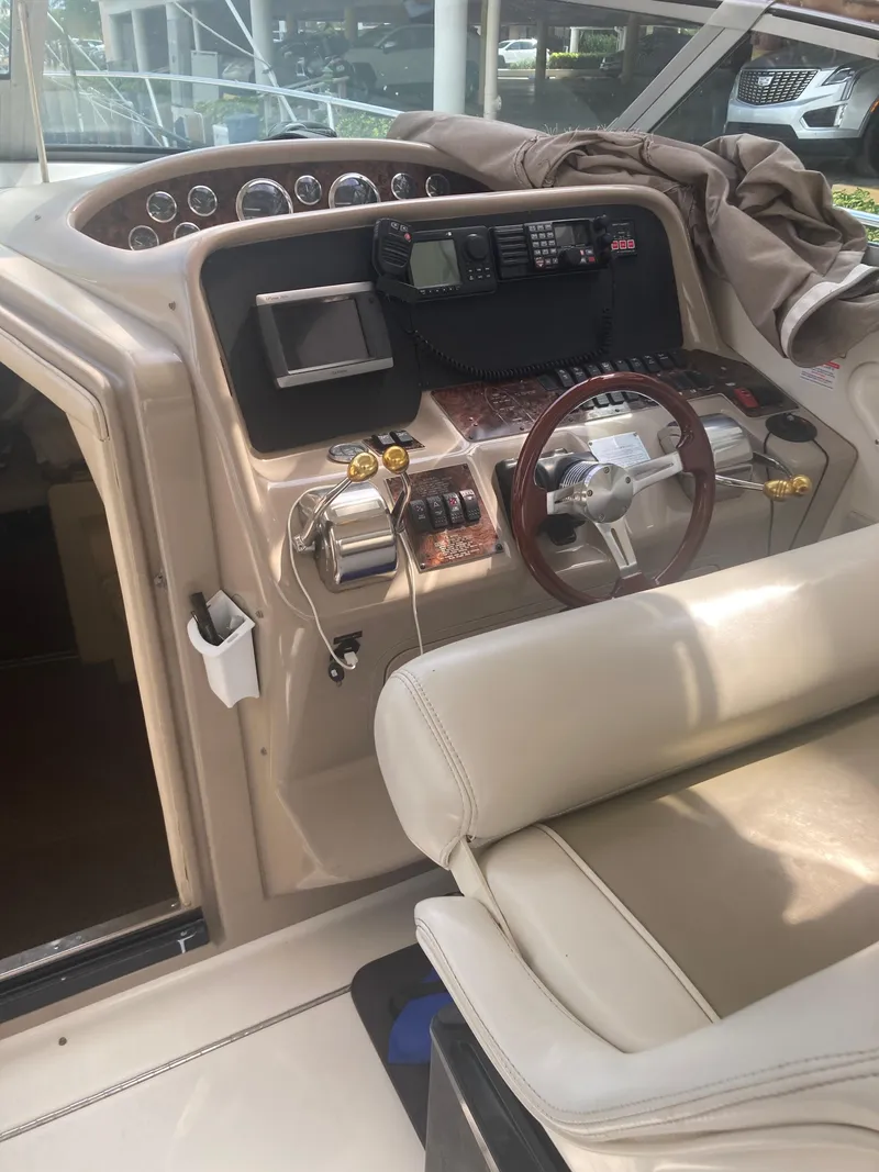 Slide: The Image of 1999 Sea Ray 330 Express Cruiser helm with steering wheel and control panel. - 28