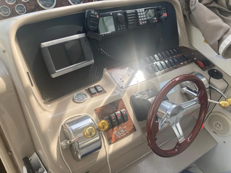 Slide: The Image of 1999 Sea Ray 330 Express Cruiser helm with steering wheel and navigation controls. - 29