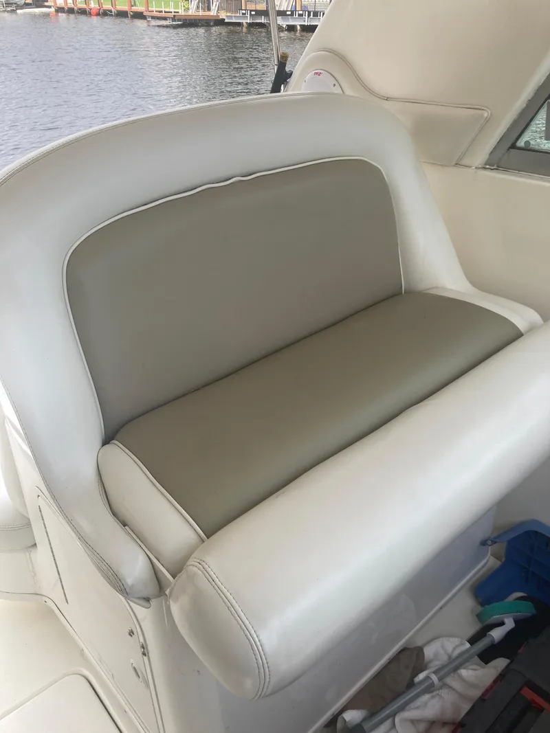 Slide: The Image of 1999 Sea Ray 330 Express Cruiser interior seating with beige and white upholstery. - 31