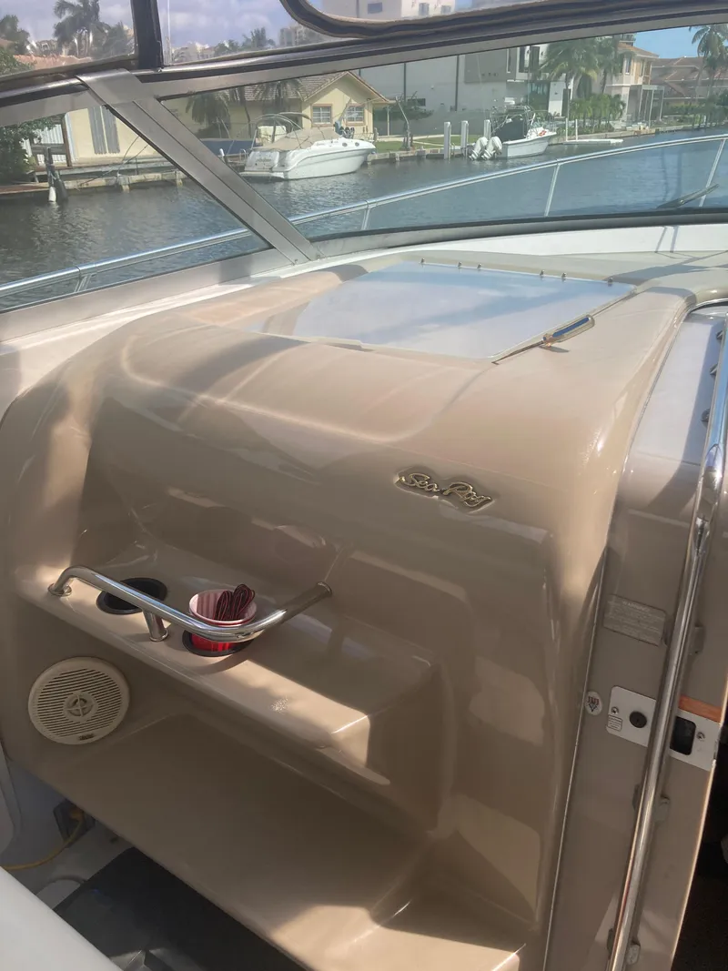 Slide: The Image of 1999 Sea Ray 330 Express Cruiser interior with cup holders and waterfront view. - 36