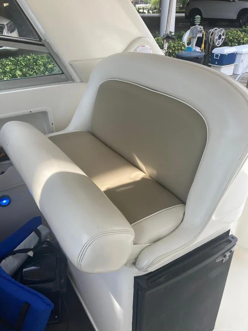 Slide: The Image of 1999 Sea Ray 330 Express Cruiser helm seat with beige and white upholstery. - 37