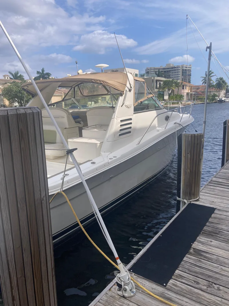 Slide: The Image of 1999 Sea Ray 330 Express Cruiser docked at marina under blue sky. - 7