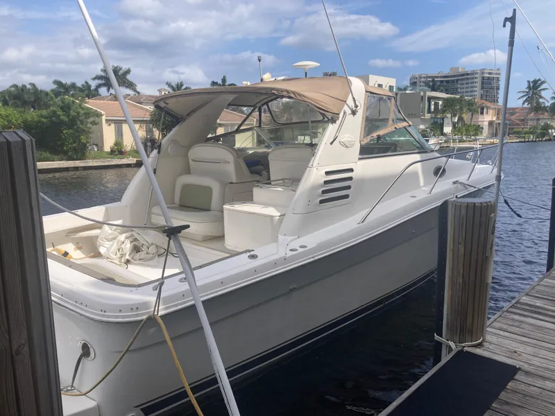 Slide: The Image of 1999 Sea Ray 330 Express Cruiser docked by waterfront homes. - 8