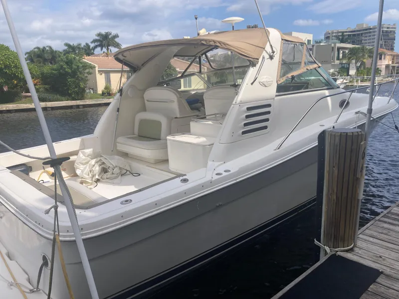 Slide: The Image of 1999 Sea Ray 330 Express Cruiser docked by waterfront homes. - 9