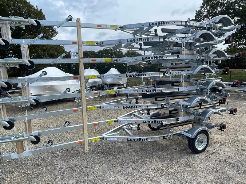 Slide: The Image of Stacked Load Rite 5s-AC23T5200 trailers, 2025 model, in outdoor storage area. - 3