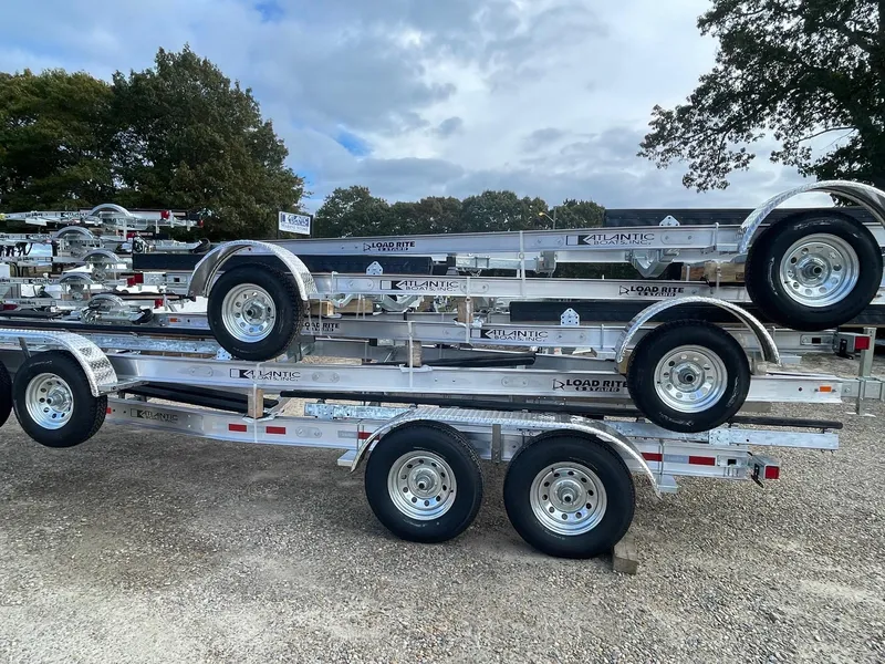 Slide: The Image of 2025 Load Rite 5s-AC23T5200 trailers stacked outdoors on gravel lot. - 4