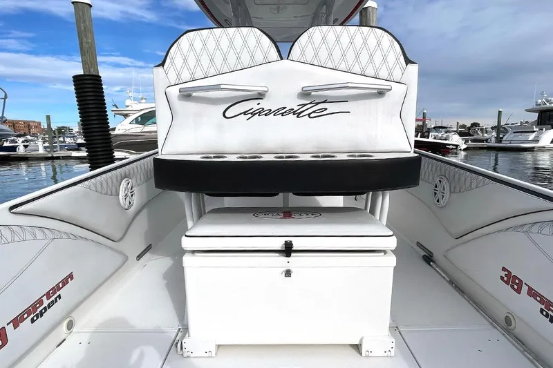 Slide: The Image of 2013 Cigarette 39 Top Gun Open boat interior with branded seating at marina. - 8